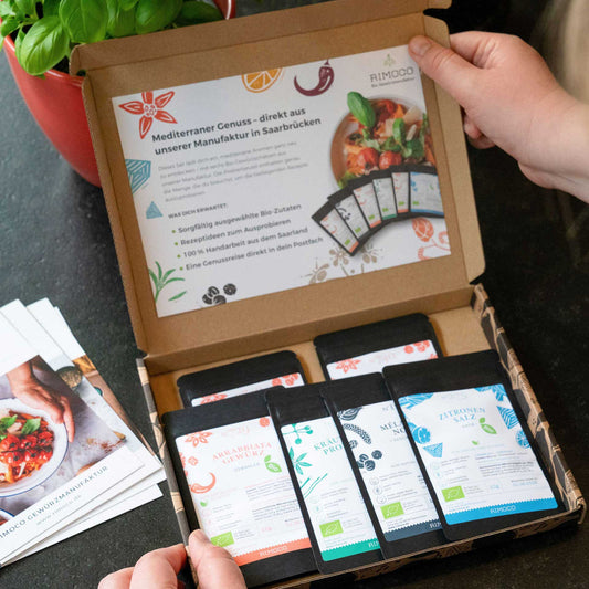 Box mit offenem Probierset Mediterrane Gewürze und beiligendem deutschen Flyer, teils sichtbar.