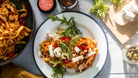 Teller Bruschetta-Pasta mit Kirschtomaten, Ziegenkäse, Pinienkernen und Rucola