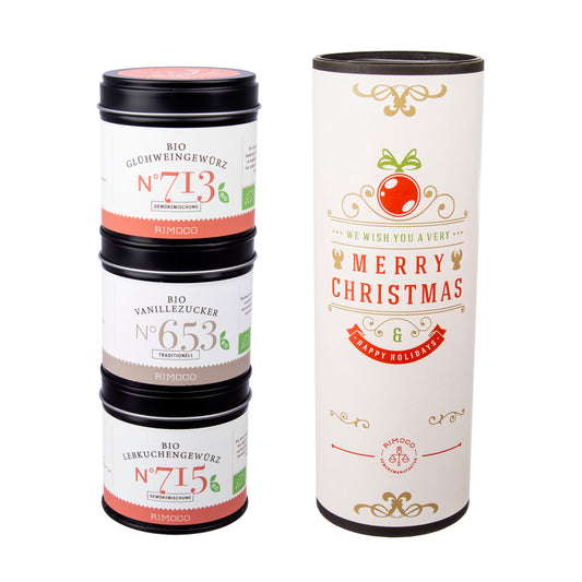 Drei Gewürzdosen gestapelt neben einem festlichen Weihnachtsgewürz-Set mit rotem Ornament.