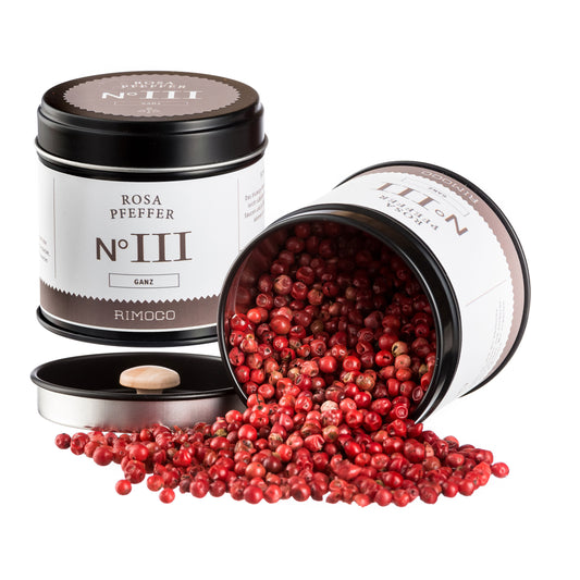 Zwei schwarze Dosen Bio Gin Botanicals würzig, eine offen mit rosa Pfefferkörnern.
