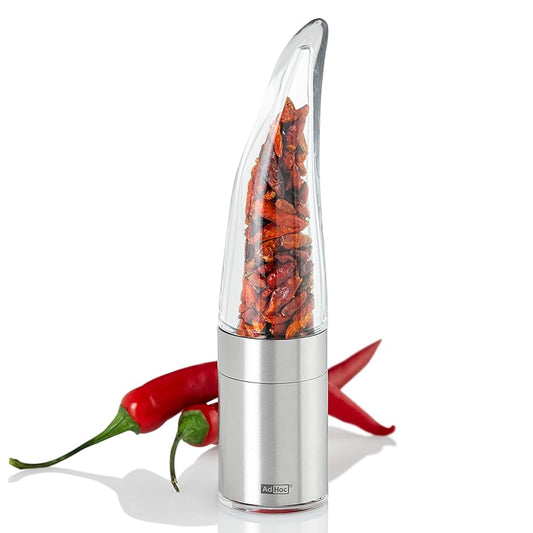 Chilischneider Pepe silber mit getrockneten Chilischoten neben frischen roten Chilischoten.