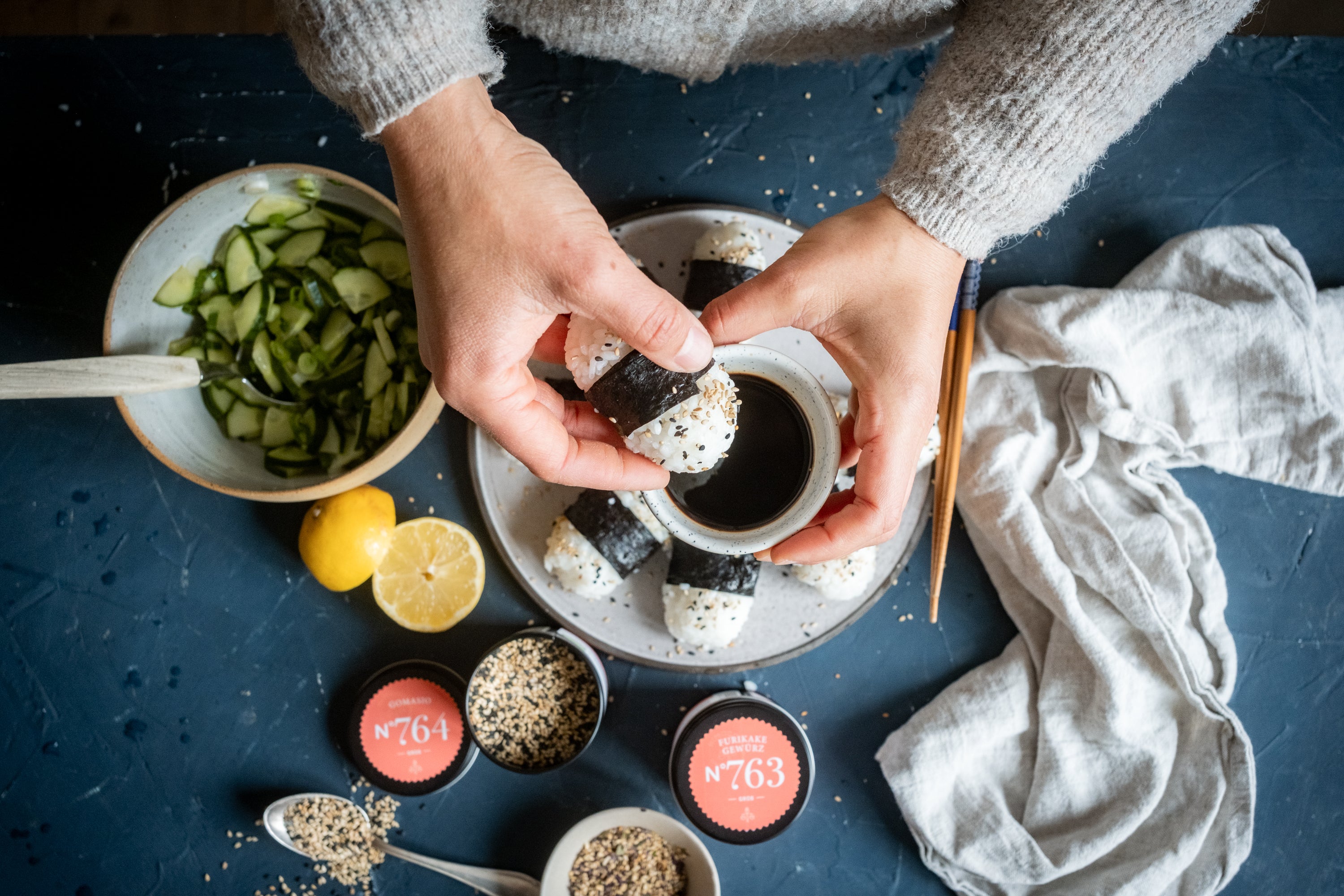 Reisbällchen mit Nori in Sojasauce dippen, dazu Gurkensalat und Nori-Blätter.