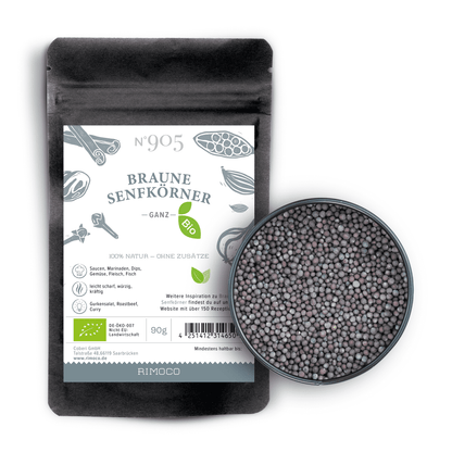 Schwarzer Beutel Bio Braune Senfkörner neben einer Schale mit Senfkörnern.