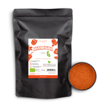 Bio Geräuchertes Paprikapulver scharf neben einer Schale mit rotem, gemahlenem Paprikapulver.
