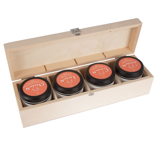 Vier Dosen mit rot-orangem Ayurveda Einsteiger Gewürz-Set Etikett in einer Holzbox.