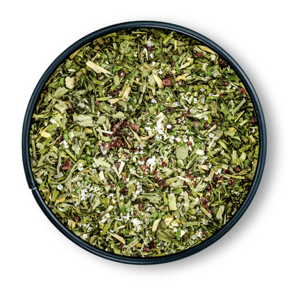 Runde Dosis Bio Salatgewürz mit grünem, getrocknetem Kräuter-Gewürz-Mix von oben gesehen.