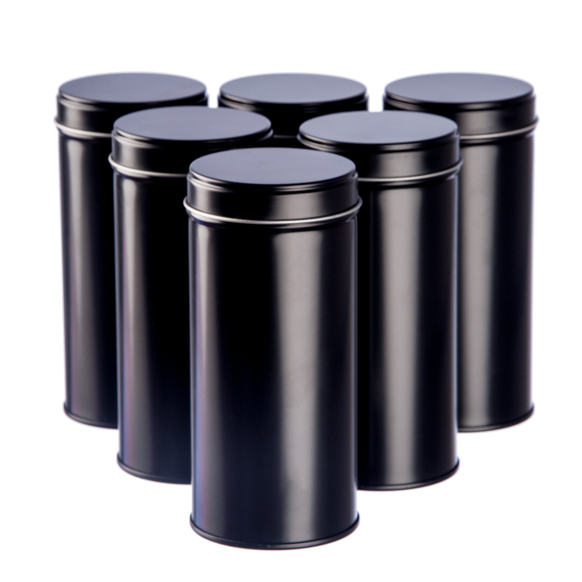Sechs schwarze Teedosen mit Aromadeckel stehen in zwei Reihen auf weißem Hintergrund.