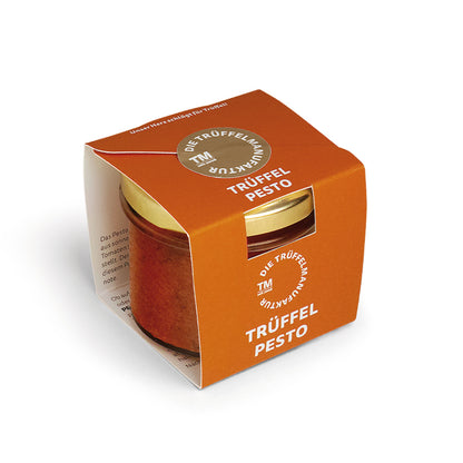 Trüffel Pesto in einem kleinen Glas mit orangener Kartonverpackung.