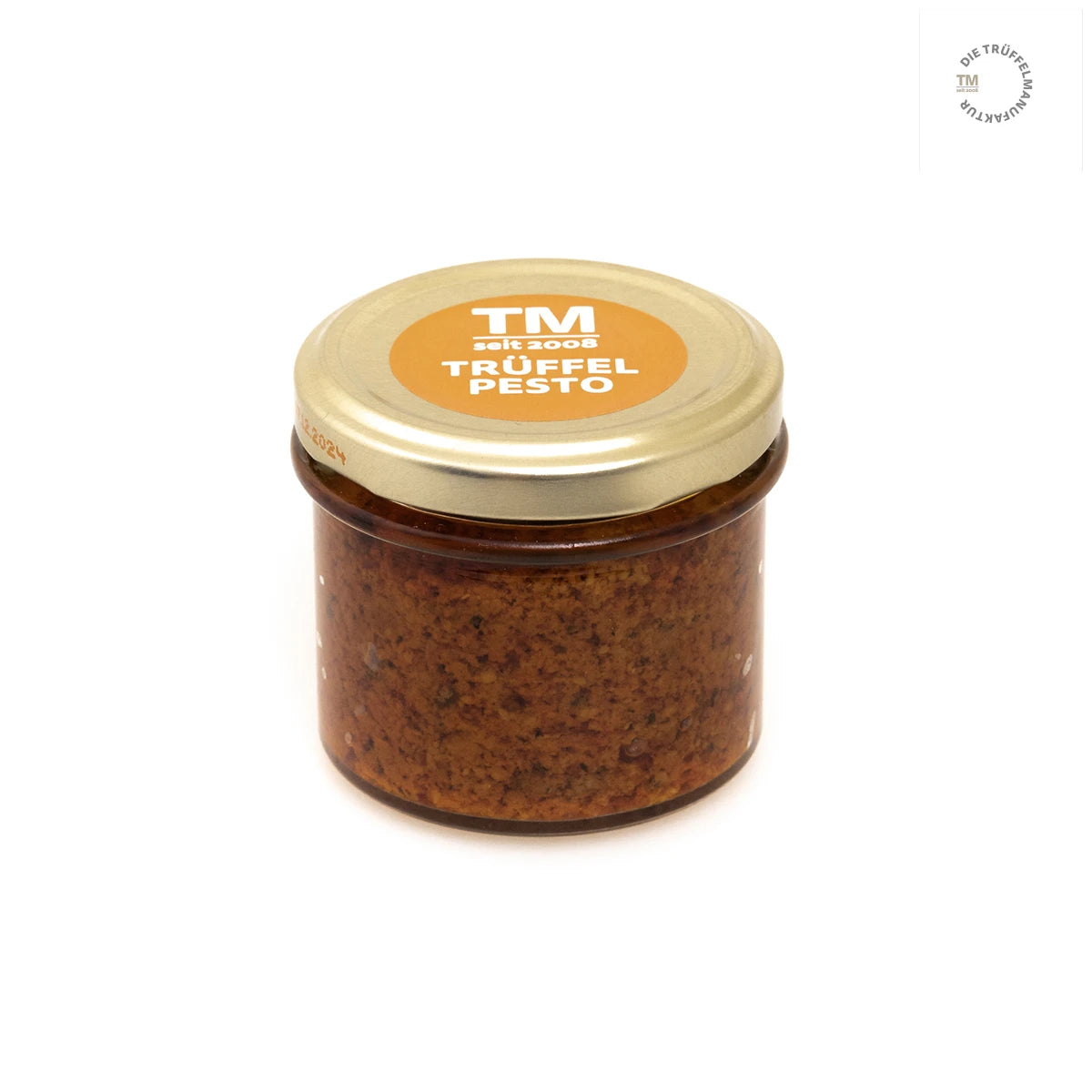 Trüffel Pesto in kleinem Glas mit goldenem Deckel und orangem Etikett auf weißem Hintergrund.